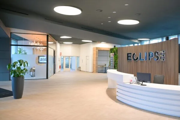 Moderne en lichte ontvangsthal van het kantoorgebouw Eclipse aan het Rivium Quadrant, met een receptiebalie en glazen vergaderruimte.